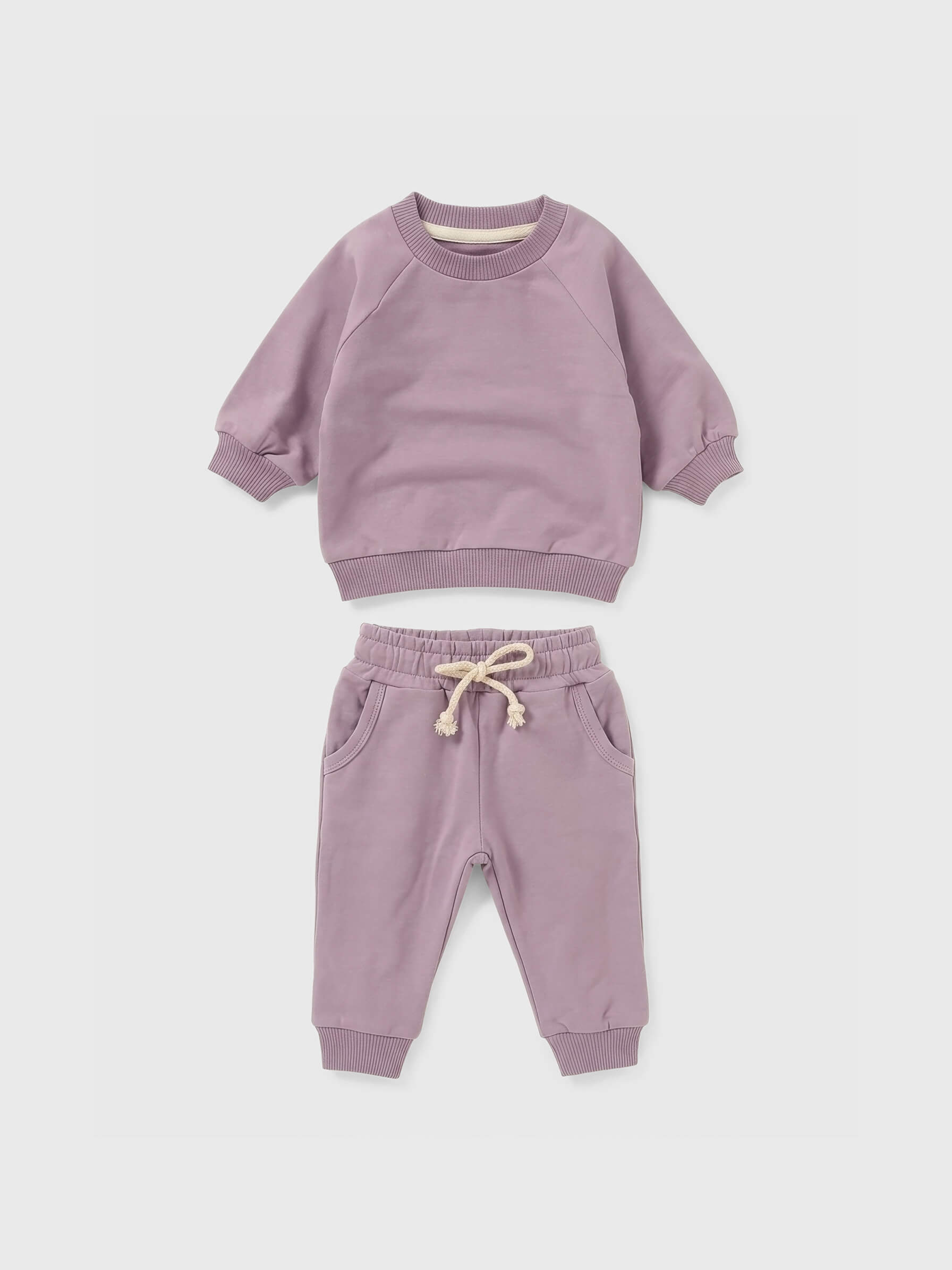 Purple sweatshirt and pants set on a white background