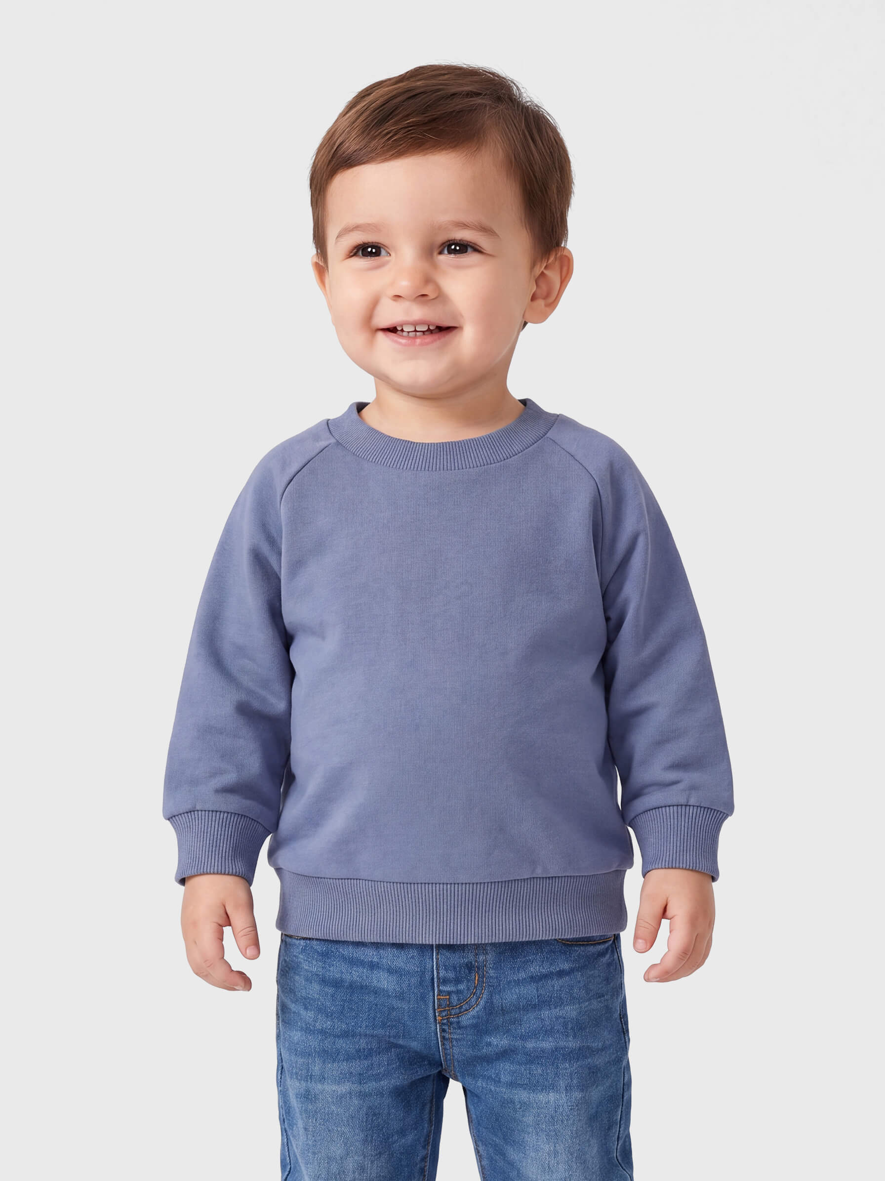 Child wearing a blue sweatshirt and jeans on a light gray background